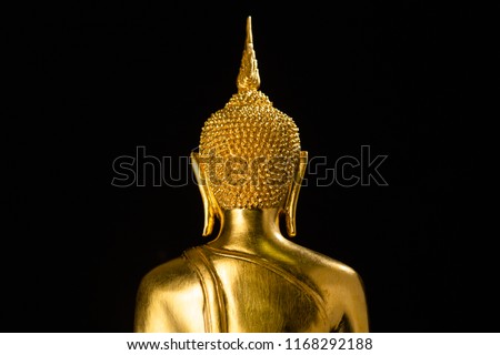 behind golden buddha closeup against a black background