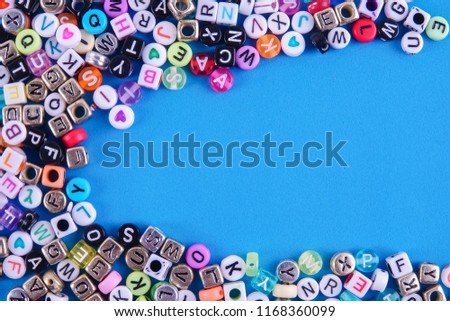 Colorful plastic alphabet dice on a blue background as a background.