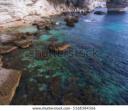 Turquoise clear waters near the rocky coast of the island of Corsica.