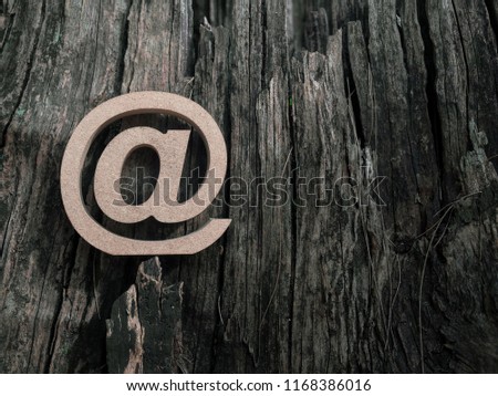 Wooden E-mail address symbol, arroba icon on old dry wooden texture background with copy space. E-mail marketing online internet, technology and environment concept.