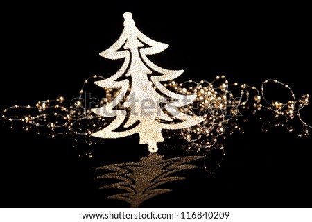 Gold Christmas tree with gold beads on black background.
