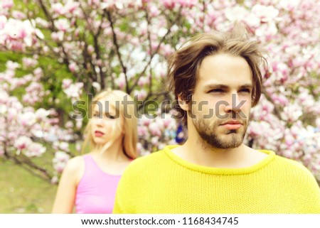 man and woman, couple in love in spring magnolia flowers, happy smiling guy and girl in garden with blossom tree outdoor on natural background