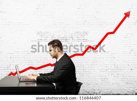 man sitting at table and graph of growth