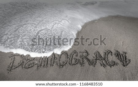 inscription DEMOCRATICY on the gray  sand