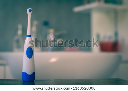electric toothbrush with unfocused bathroom background.