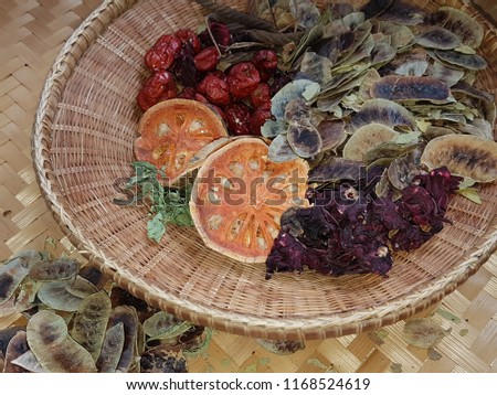 Crops of dry various natural Thai herbs medicine on bamboo basket. herbal healthy nature picture concept.