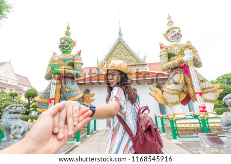 Tourist asian women leading boyfriend hand to travel in buddha temple of dawn, Bangkok Thailand