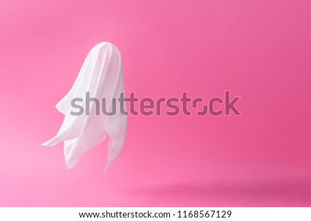 White ghost sheet costume against pastel pink background. Minimal Halloween scary concept. Royalty-Free Stock Photo #1168567129