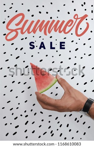 cropped shot of man holding watermelon piece in hands on white surface with summer sale lettering
