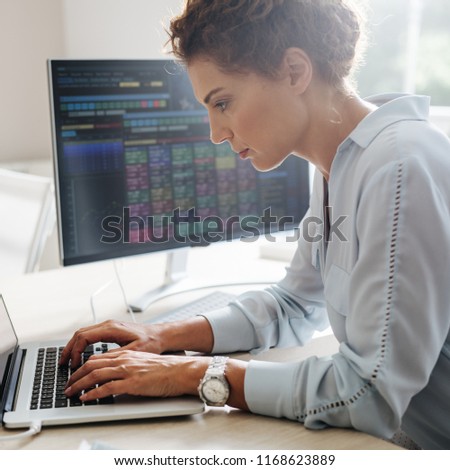 Young businesswoman working on a laptop at the modern office space.
