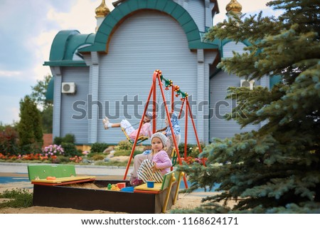 little Russian Orthodox girl playing near the Orthodox Church on the Playground.
