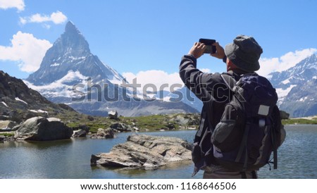 Old Man Taking Pictures With Mobile Smartphone Of Mountain and Landscape
