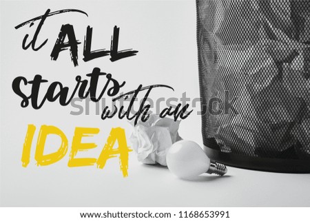 light bulb with crumpled papers in office trash bin on white with "it all starts with an idea" inspiration