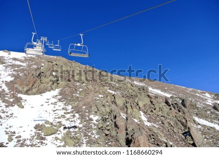 Gondola lifts are running up and down against the mountain and bright blue clear sky, Gudauri, Georgia