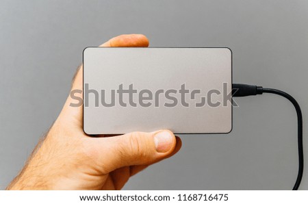 Man showing power bank for charging mobile devices also know as external battery for mobile devices such as smartphones, tablets and wearable devices