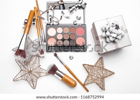 Set of cosmetics with Christmas present and decorations on white background