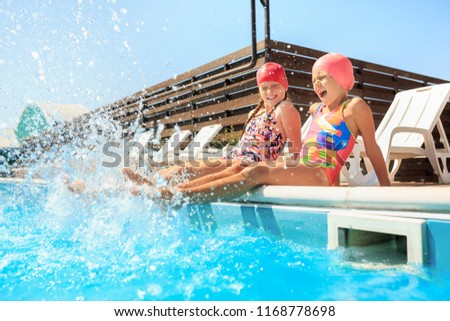 The portrait of happy smiling beautiful teen girls at the swimming pool. Little child at blue wate. Pool, leisure, swimming, summer, recreation, healthy lifstyle concept