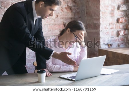 Colleague, boss or advisor explains, criticize the work of young girl intern in office. Subordinate feels guilty tired, frustrated and exhausted, having headache at workplace. Businesspeople arguing Royalty-Free Stock Photo #1168791169