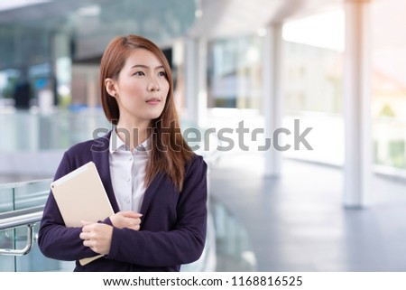 Business woman holding tablet in city with copy space