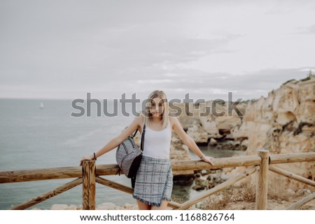 Young woman with backpack Traveler on background beach seascape horizon.