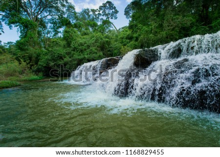 beautiful waterfall among the tree in the deep forest are background. this image for nature landscape forest wild concept