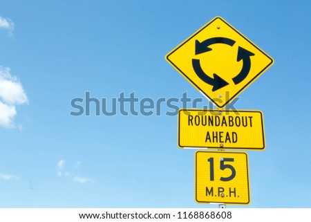 Traditional American roundabout ahead road warning sign