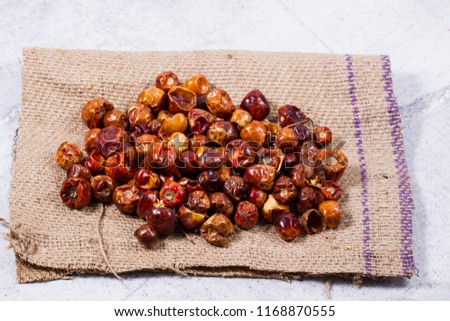 Dried whole round Chillis from low perspective isolated on white wood.