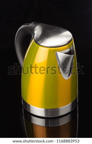 Yellow painted stainless steel electrical kettle on black mirror background