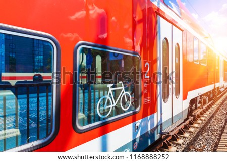 Creative abstract railroad travel and railway transportation industrial concept: modern red high speed electric passenger commuter double deck train with bicycle symbol or sign at the station platform