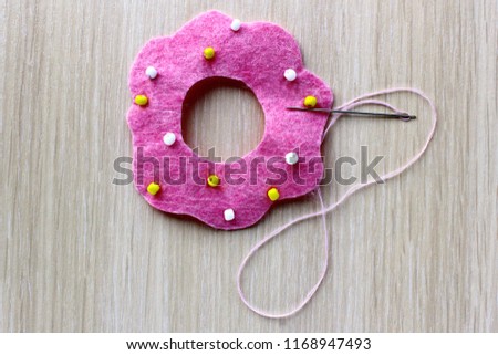 Cool donut step by step. Handmade for girl, boy and children. Step 9. Chaotically sew red beads in pink circle.