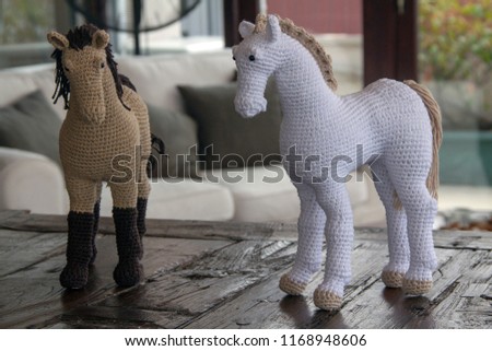 crocheted amigurumi horses on a wooden table
