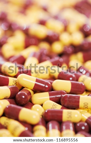 Pharmacy theme, Heap of yellow brown capsule pills with medicine antibiotic. Shallow DOF