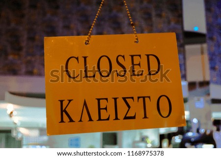 Closed sign board hanging on the glass of a store window in Larnaca, Cyprus. Greek version of the word.
