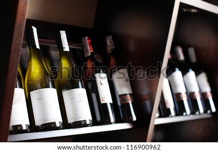 Wine bottles on a wooden shelf. Wine cellar background.