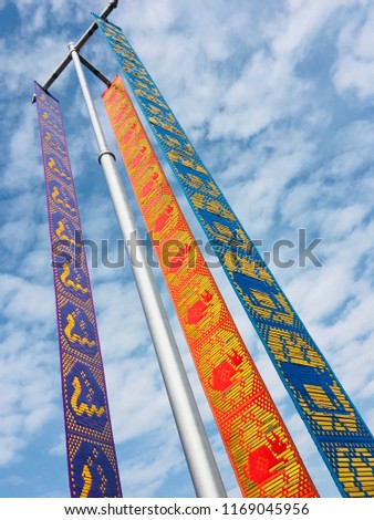 Traditional Lanna Flag (Tung) with zodiac signs made from long fabric sheet hanged on pole, Chiang Rai, Thailand