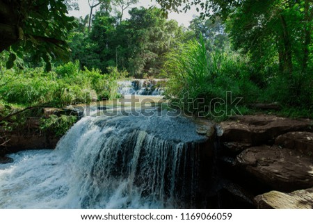 beautiful waterfall among the tree in the deep forest are background. this image for nature landscape forest wild concept