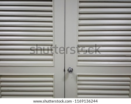 The door is made of gray wood with a silver knob.
