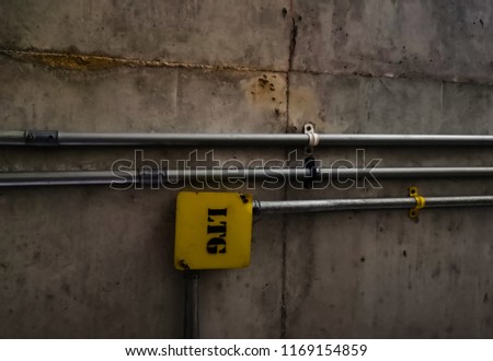 Steel pipe with a separate band on the cement wall Inside the building. Empty with copy space for text.