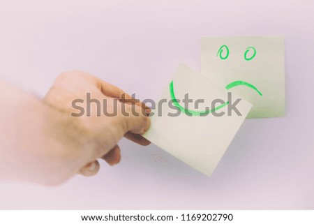 in the white background and empty space the smile in the memo  like concept of emotions and hands
