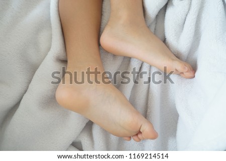 Boy feet during sleeping on bed.