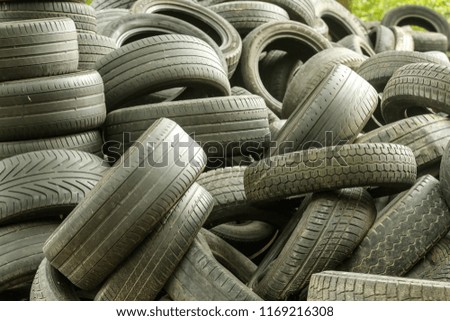 A picture of many old used tires left on a waste dump. The picture of an ecological problem and disaster. 