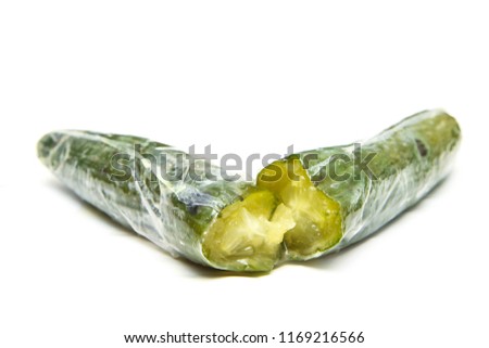 A picture of a rotten cucumber packed in the plastic foil. The foil is useless, it only damages the vegetable and it only goes mouldy. Isolated on a white background. 