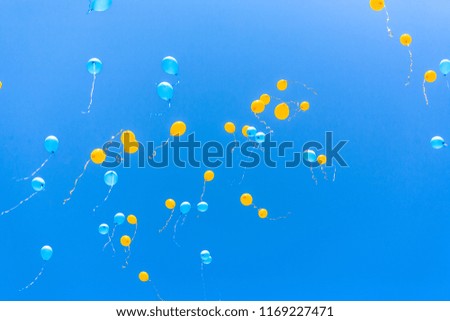 Yellow and blue balloons in sky