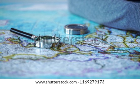 Magnifying glass and compass on map, adventure planning, vacation travel