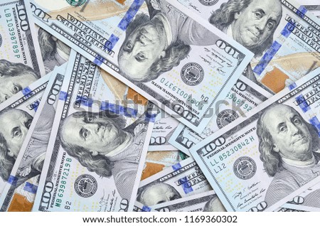 A large number of US dollar bills of a new design with a blue stripe in the middle. Top view