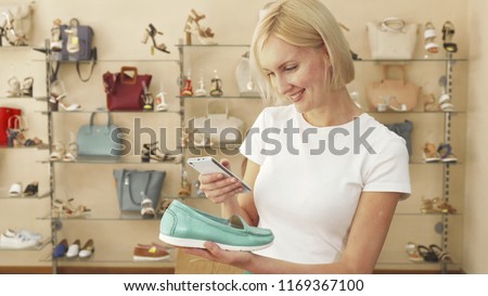 Blonde surfing her phone and holding a shoe. Then she takes a picture of shoe and continue surfing the net