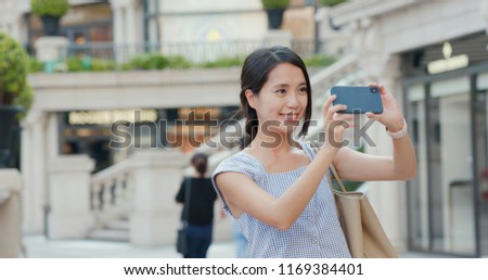 Woman taking photo on cellphone at outdoor