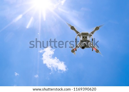 drone copter flying with digital camera.Drone with high resolution digital camera. Flying camera take a photo and video.The drone with professional camera takes pictures of the blue sky.
