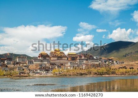 Beautiful view of the Ganden Sumtseling Monastery or another name is Songzanlin Monastery under the clouds and blue sky in sunny day, Shangri-la County, Yunnan Province, China Royalty-Free Stock Photo #1169428270
