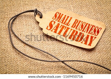 Small Business Saturday sign - a paper price tag with a twine iagainst burlap canvas Royalty-Free Stock Photo #1169450716